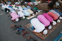 India, West Bengal, Kolkata, Muslim men at prayer on MG Road.