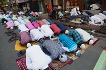 India, West Bengal, Kolkata, Muslim men at prayer on MG Road.