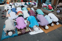 India, West Bengal, Kolkata, Muslim men at prayer on MG Road.
