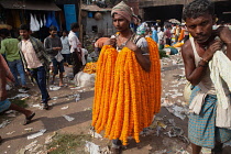 India, West Bengal, Kolkata, Marigold vendor at Malik Ghat flower market.