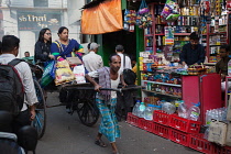 India, West Bengal, Kolkata, A rickshaw driver pulls passengers through the streets.