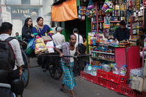 India, West Bengal, Kolkata, A rickshaw driver pulls passengers through the streets.