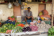 India, West Bengal, Kolkata, Vendor at the vegetable market in the Garia district.