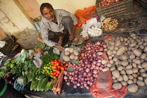 India, West Bengal, Kolkata, Vendor at the vegetable market in the Garia district.