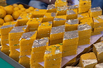 India, West Bengal, Kolkata, Display of diamond-shaped burfi or barfi Indian sweets in a shop.