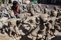 India, West Bengal, Kolkata, A sculptor moulding durga idols in the Kumartuli district.