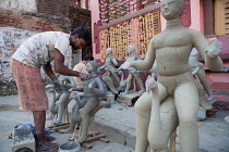 India, West Bengal, Kolkata, A sculptor creating durga idols in the Kumartuli district.