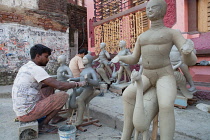 India, West Bengal, Kolkata, A sculptor creating durga idols in the Kumartuli district.