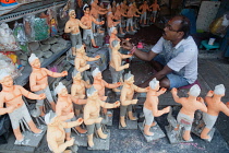 India, West Bengal, Kolkata, A painter adds colour to durga statues in the Kumartuli district.
