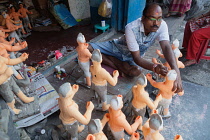 India, West Bengal, Kolkata, A painter adds colour to durga statues in the Kumartuli district.