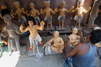 India, West Bengal, Kolkata, A painter adds colour to a durga statue in the Kumartuli district.