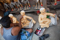 India, West Bengal, Kolkata, A painter adds colour to a durga statue in the Kumartuli district.