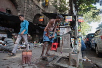 India, West Bengal, Kolkata, A man collects water at a road-side pump.