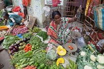 India, West Bengal, Kolkata, Vendor in the vegetable market in the Garia district.