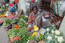 India, West Bengal, Kolkata, Vendor in the vegetable market in the Garia district.