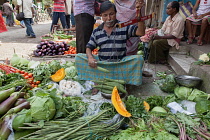 India, West Bengal, Kolkata, Vendor in the vegetable market in the Garia district.