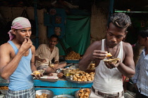 India, West Bengal, Kolkata, Men eat samosas and kachori.
