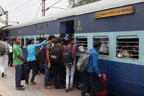 India, West Bengal, Asansol, Passengers attempt to board an overcrowded second-class carriage of a train at Railway Station.