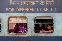 India, West Bengal, Asansol, Passengers at the window of a train carriage for the 'differently abled' at railway station.
