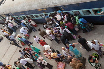 India, Bihar, Gaya, Passengers attempt to board an overcrowded second class carriage of a train at Railway Station.