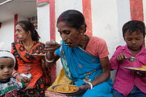 India, Bihar, Bodhgaya, A family eating vegetarian street food in Bodh.