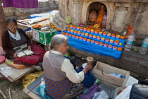 India, Bihar, Bodhgaya, Pilgrims from Tibet pray in front of a statue of the Buddha at the Mahabodhi Temple at Bodh.