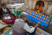 India, Bihar, Bodhgaya, Pilgrims from Tibet pray in front of a statue of the Buddha at the Mahabodhi Temple at Bodh.