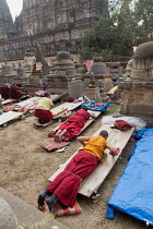 India, Bihar, Bodhgaya, Buddhist monks prostrate themselves in front of the Mahabodhi Temple in Bodh.