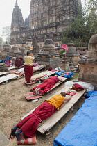 India, Bihar, Bodhgaya, Buddhist monks prostrate themselves in front of the Mahabodhi Temple in Bodh.