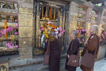 India, Bihar, Bodhgaya, Buddhist monks pray at the shrine at the base of the Bodhi tree at the Mahabodhi Temple in Bodh.