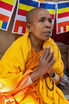 India, Bihar, Bodhgaya, A Buddhist female monk prays at the Mahabodhi Temple in Bodh.