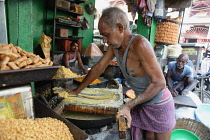 India, Bihar, Gaya, A cook preparing chat and namkeen at a food hotel.