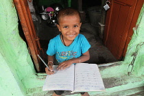 India, Bihar, Gaya, A smiling boy completing homework.