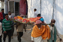 India, Bihar, Gaya, A body is carried through the streets of to the cremation site on the ghats of the Phalgu River.