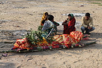India, Bihar, Gaya, A bereaved family grieve over the body of a deceased relative before its cremation.