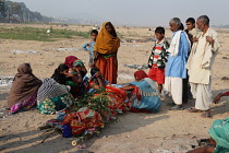 India, Bihar, Gaya, A bereaved family grieve over the body of a deceased relative before its cremation.