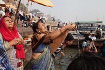 India, Uttar Pradesh, Varanasi, Pilgrims praying at Dashashwamedh Ghat beside the River Ganges.