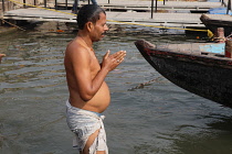 India, Uttar Pradesh, Varanasi, Pilgrim praying in the River Ganges.