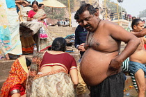 India, Uttar Pradesh, Varanasi, An obese pilgrim bathes in the River Ganges.