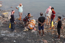 India, Uttar Pradesh, Varanasi, A shrouded body beside the River Ganges in before its cremation at Harishchandra Ghat.