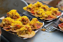 India, Uttar Pradesh, Varanasi, Street food vegetables on kachoris sprinkled with a rice topping.