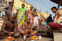 India, Uttar Pradesh, Varanasi, A bereaved family at a puja on Kedar Ghat.