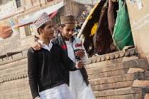 India, Uttar Pradesh, Varanasi, Muslim men look at their iphone on the ghats.