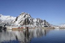 Norway, Lofoten, Svolvaer, Harbour looking towards mountains with new apartments and older fishing industry buildings in the foreground.