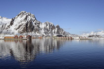 Norway, Lofoten, Svolvaer, Harbour looking towards mountains with new apartments and older fishing industry buildings in the foreground.