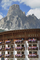 Italy, Trentino Alto Adige, Corvara, hotel with Cunterinesspitzen backdrop.