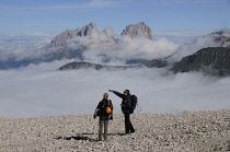 Italy, Trentino Alto Adige, Marmolada, view across to Sasso Lungo mountain range with hikers.