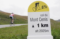 Italy, Valle d'Aosta, cycle gradient sign with cyclist passing, Col du Mont Cenis.