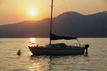 Italy, Veneto, Lake Garda, sunset over lake with boat.