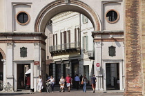 Italy, Lombardy, Crema, arch of Torazzo with people walking through.